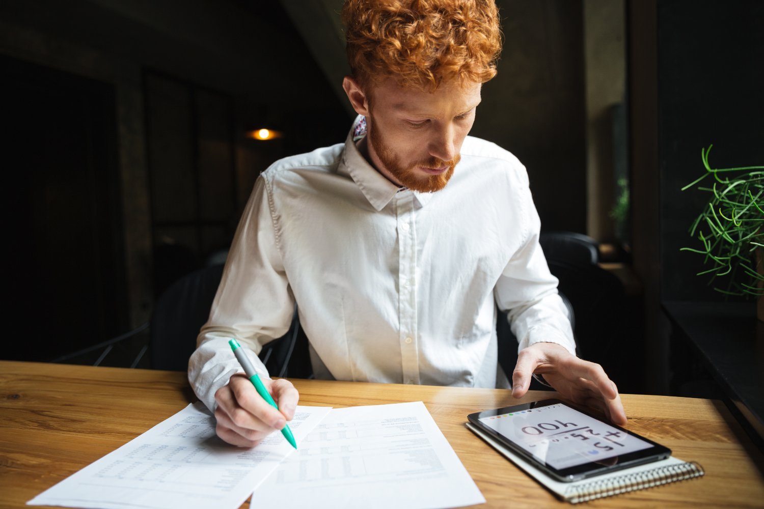 Shot of serious readhead young freelancer working at-home